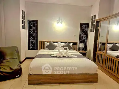 Elegant bedroom with stylish decor and mirrored wardrobe, perfect for a cozy retreat.