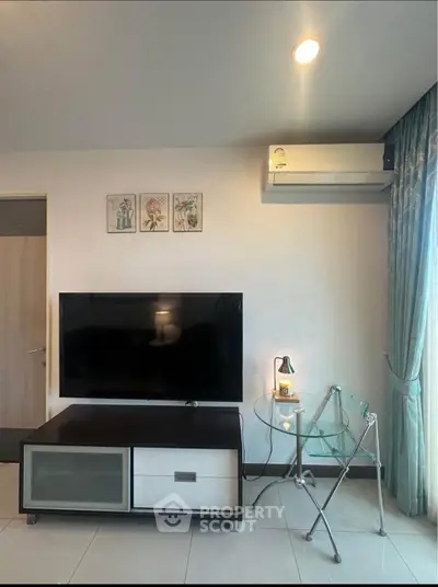 Modern living room with sleek TV setup and stylish glass table