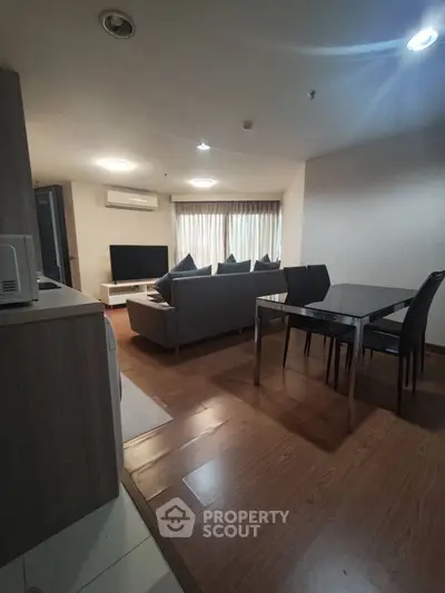 Modern living room with wooden flooring and sleek furniture in a cozy apartment.