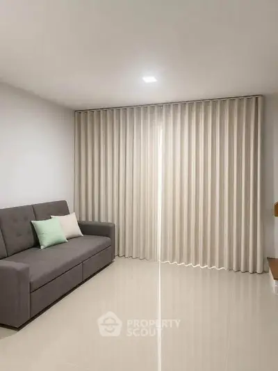 Modern living room with sleek sofa and elegant floor-to-ceiling curtains