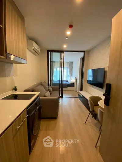 Modern studio apartment with open layout, featuring cozy living area and compact kitchen.