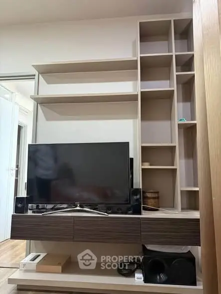 Modern living room with sleek TV unit and open shelving, perfect for stylish home entertainment setup.