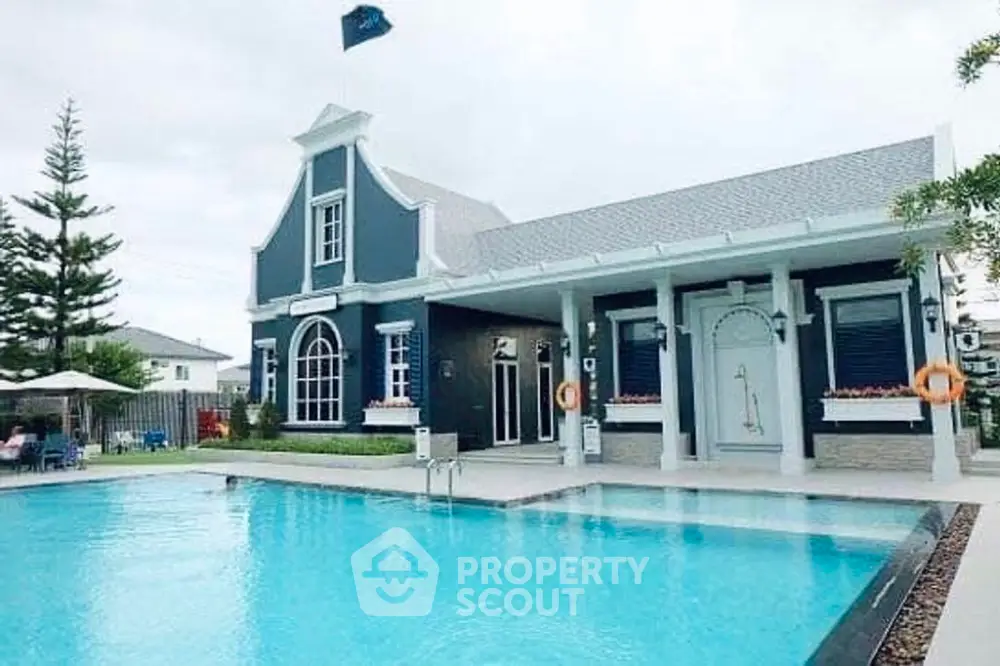 Charming blue and white themed house with a spacious outdoor swimming pool, surrounded by lush greenery and a serene environment, perfect for luxurious living.