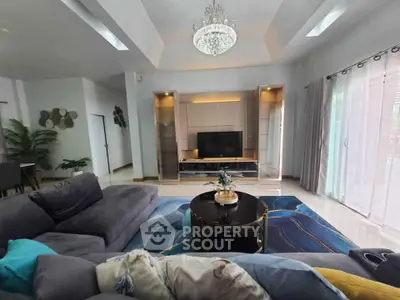 Luxurious living room with modern decor, plush sofa, and elegant chandelier.