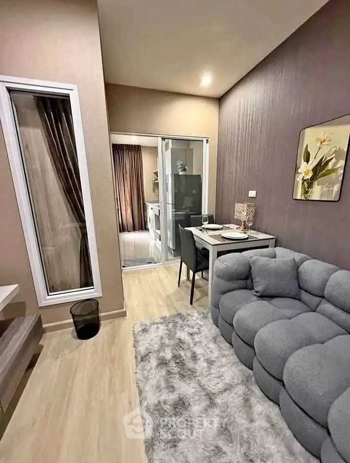 Modern living room with cozy gray sofa and dining area in stylish apartment.