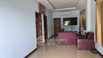 Spacious living room with elegant decor and modern amenities, featuring a comfortable seating area and wall-mounted TV.