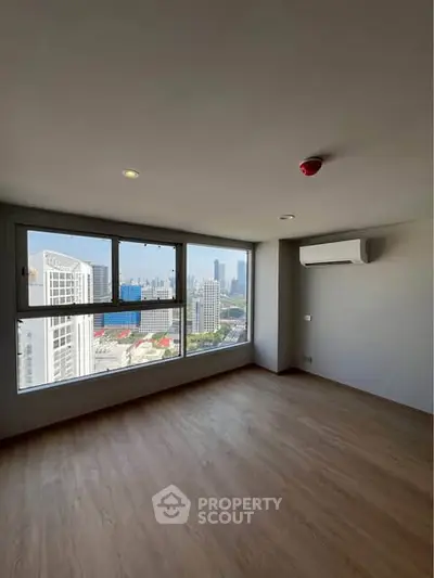 Spacious empty room with large windows offering stunning city views, perfect for customization.