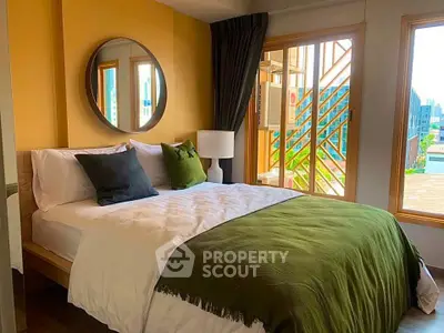 Cozy bedroom with modern decor and large windows offering natural light and city views.