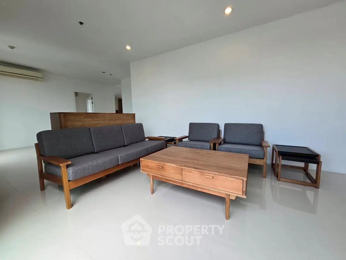 Spacious living room with modern wooden furniture and sleek design.