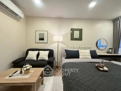 Modern bedroom with cozy decor, featuring a stylish bed, elegant sofa, and chic lighting.