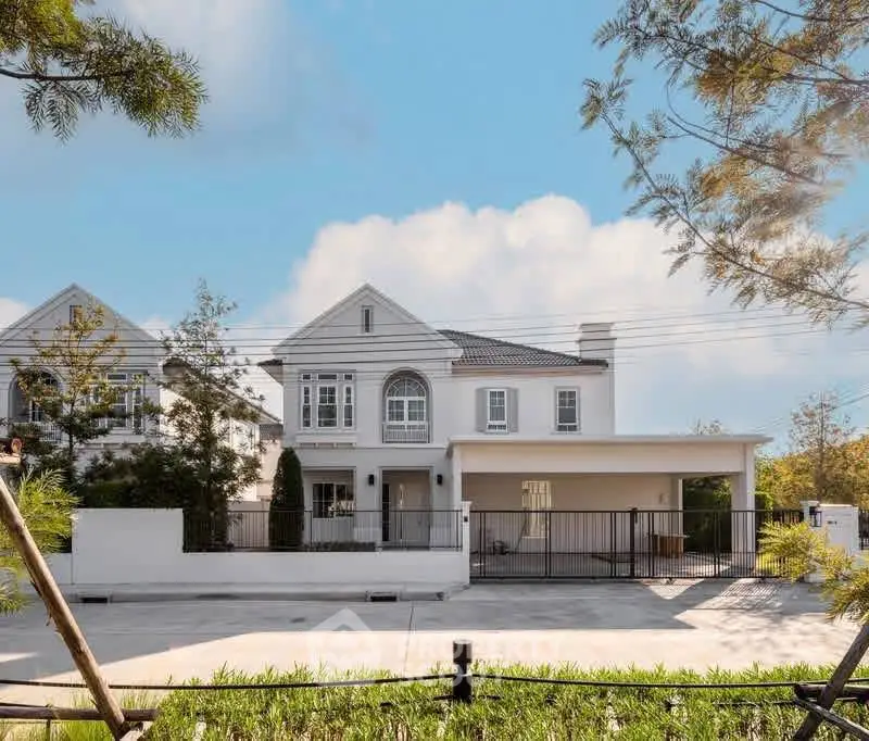 Elegant two-story white house with spacious driveway and lush greenery, perfect for family living.