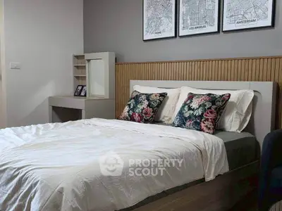 Cozy bedroom with stylish decor and floral pillows, perfect for relaxation and comfort.