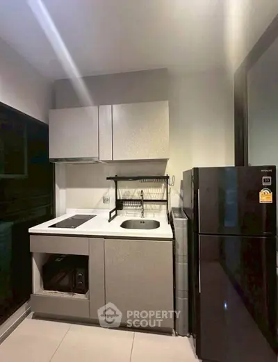 Modern compact kitchen with sleek cabinetry and black appliances