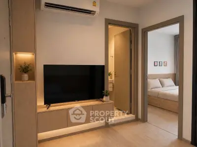 Modern apartment interior with cozy living room and bedroom, featuring sleek furniture and warm lighting.