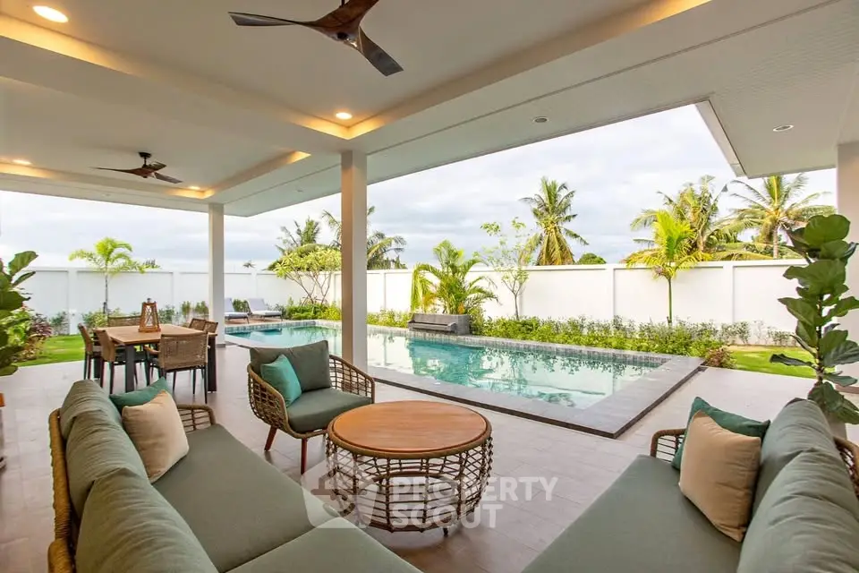 Luxurious outdoor patio with pool and tropical garden view, perfect for relaxation and entertaining.