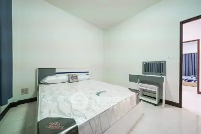 Spacious bedroom with modern furniture and natural light, perfect for comfortable living.