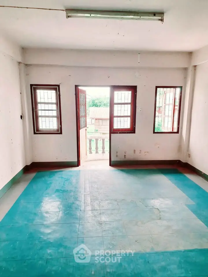 Spacious room with large windows and balcony access, perfect for natural light lovers.