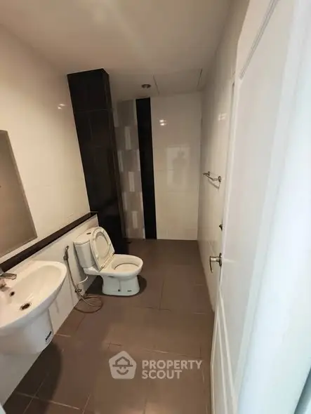 Spacious modern bathroom with sleek fixtures and neutral tiles.