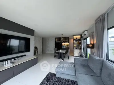 Spacious modern living room with sleek furniture and open kitchen layout