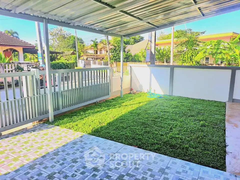 Charming covered patio with lush green lawn and tiled flooring in a serene neighborhood.