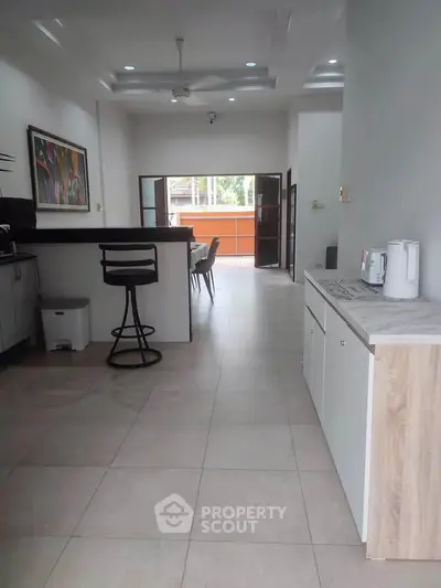 Spacious open-plan kitchen and dining area with modern decor and ample natural light.