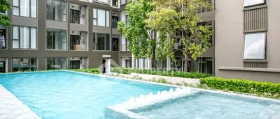 Modern apartment complex with refreshing outdoor pool and lush greenery.