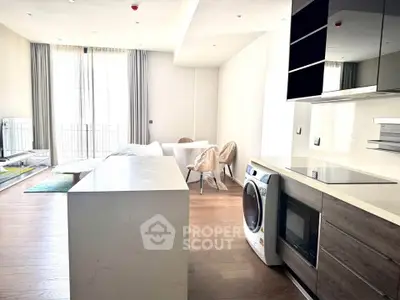 Modern open-plan kitchen and living area with sleek appliances and natural light.