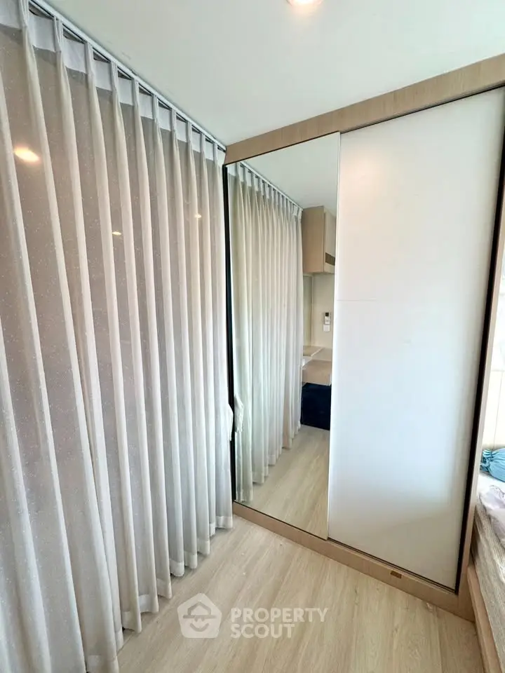 Modern bedroom with mirrored wardrobe and elegant curtains