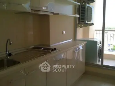 Modern kitchen with sleek cabinetry and balcony view