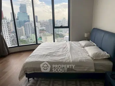 Luxurious bedroom with stunning city view and modern furnishings in high-rise apartment.