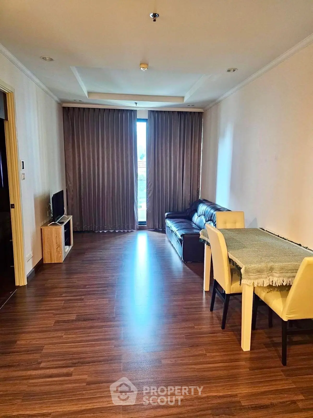 Spacious living room with modern decor and wooden flooring, perfect for relaxation and entertainment.