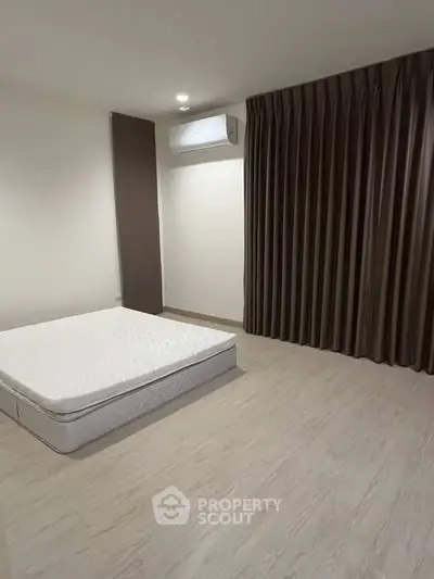 Spacious bedroom with minimalist decor and natural light