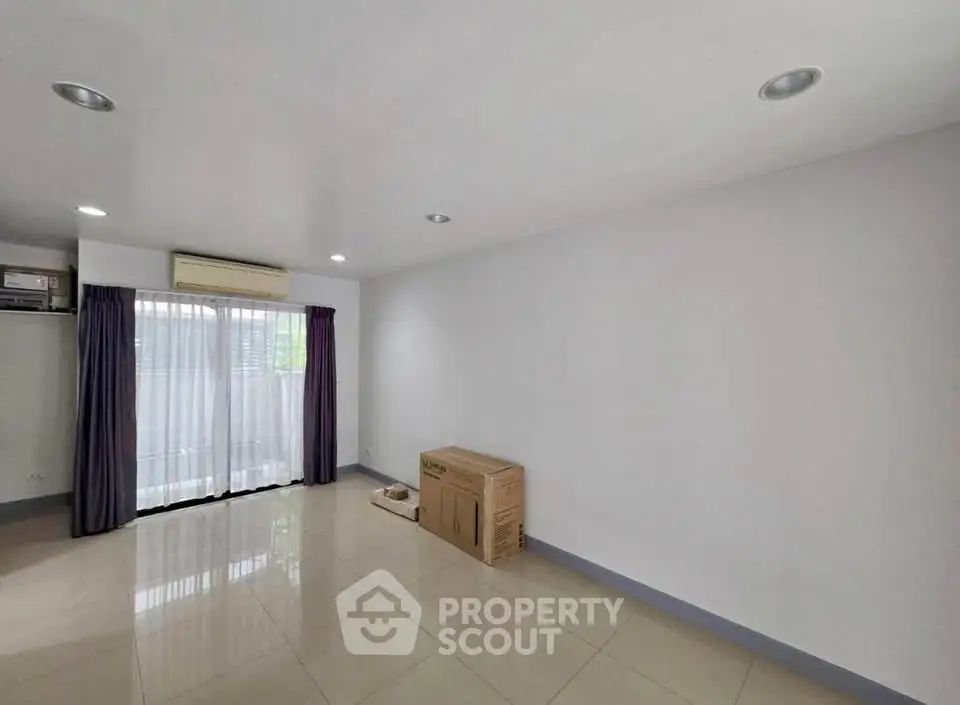 Spacious empty room with large window and air conditioning unit