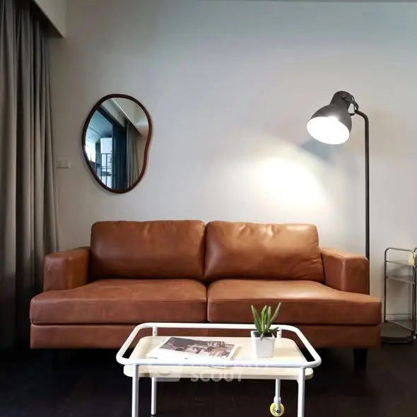 Stylish living room with brown leather sofa and modern floor lamp