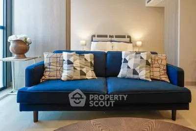 Stylish modern living room with blue sofa and geometric pillows, perfect for cozy relaxation.