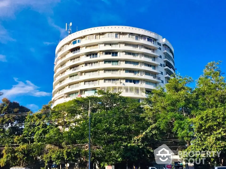 Stunning modern round building with lush greenery and clear blue sky