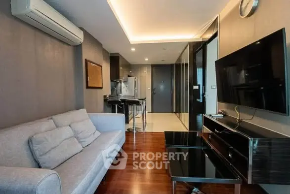 Modern living room with sleek furniture and open kitchen layout in a stylish apartment.