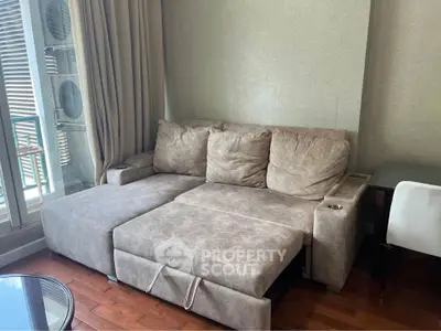 Cozy living room with plush sectional sofa and wooden flooring, perfect for relaxation and comfort.