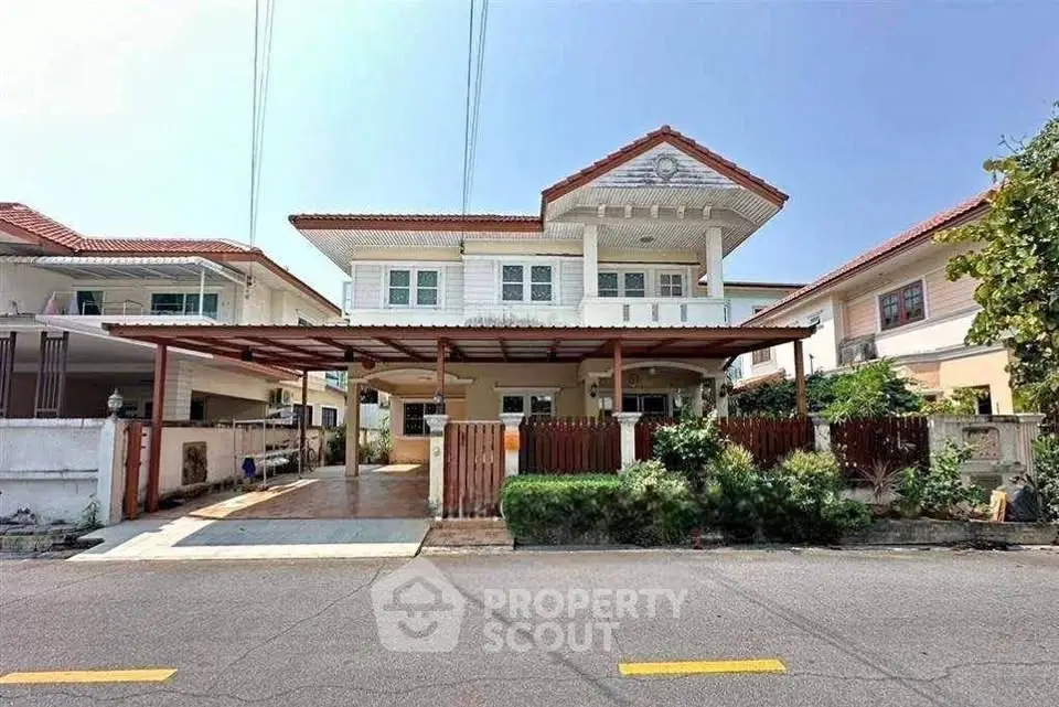 Charming two-story house with spacious driveway and lush greenery in a serene neighborhood.