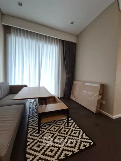 Modern living room with sleek furniture and large window, featuring a 4K UHD TV box.