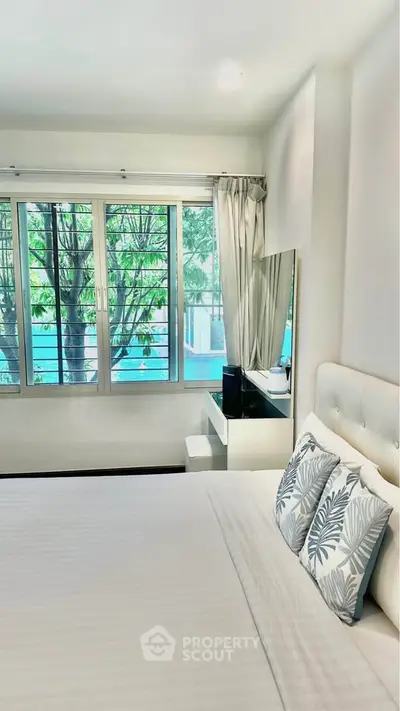 Bright bedroom with large window and stylish decor