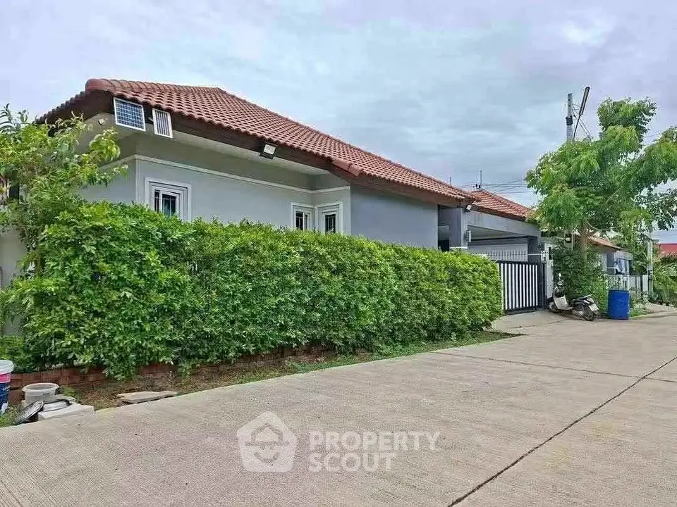 Charming suburban house with red-tiled roof and lush greenery, perfect for family living.