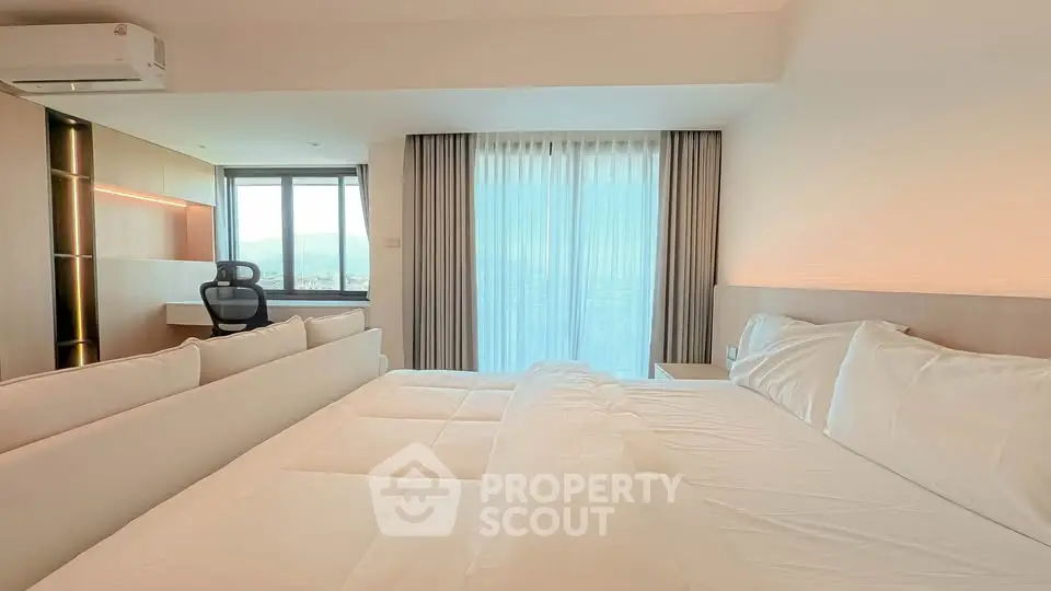 Luxurious bedroom with stunning view and modern workspace, perfect for comfort and productivity.