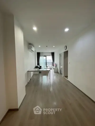 Spacious modern living room with minimalist decor and large windows for natural light.