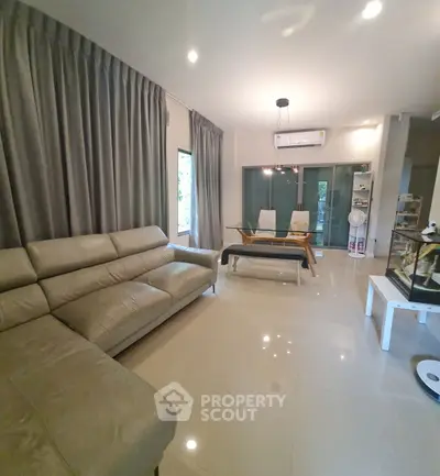 Spacious modern living room with elegant leather sofa and chic dining area
