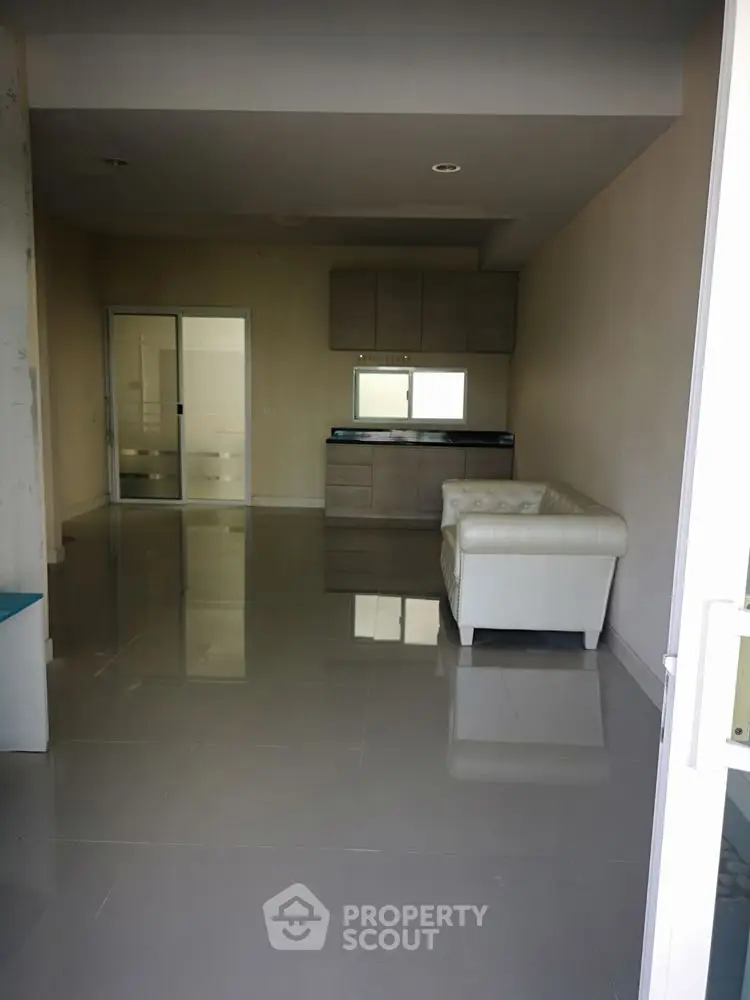 Spacious modern living room with sleek flooring and cozy white sofa