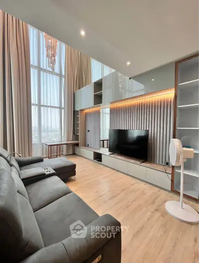 Luxurious high-ceiling living room with modern decor and large windows
