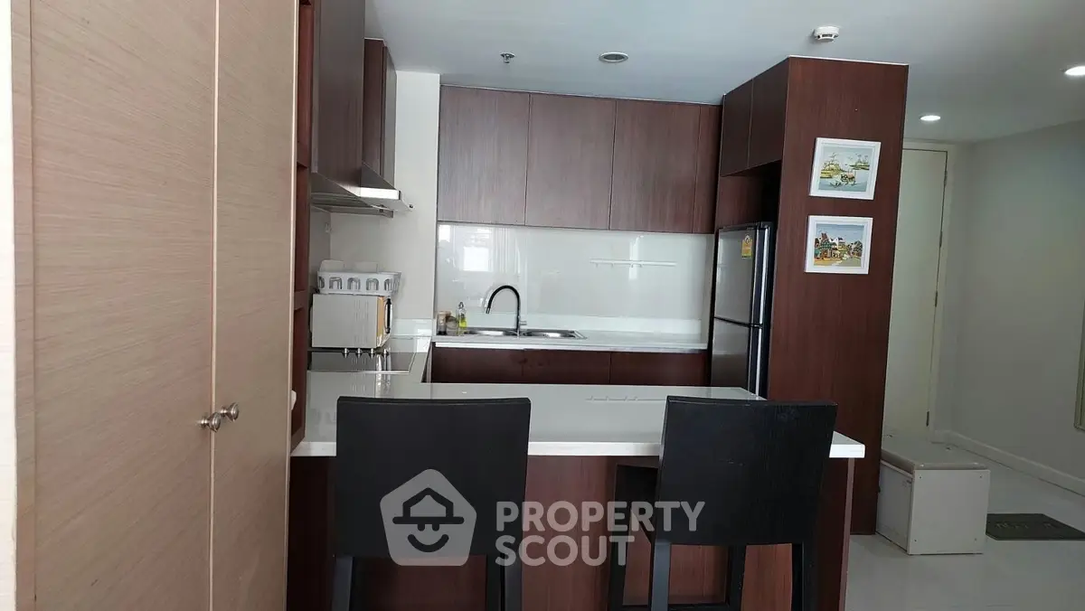 Modern kitchen with sleek cabinetry and breakfast bar in stylish apartment