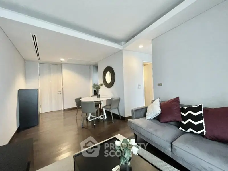 Modern living room with stylish decor and dining area in open layout apartment.