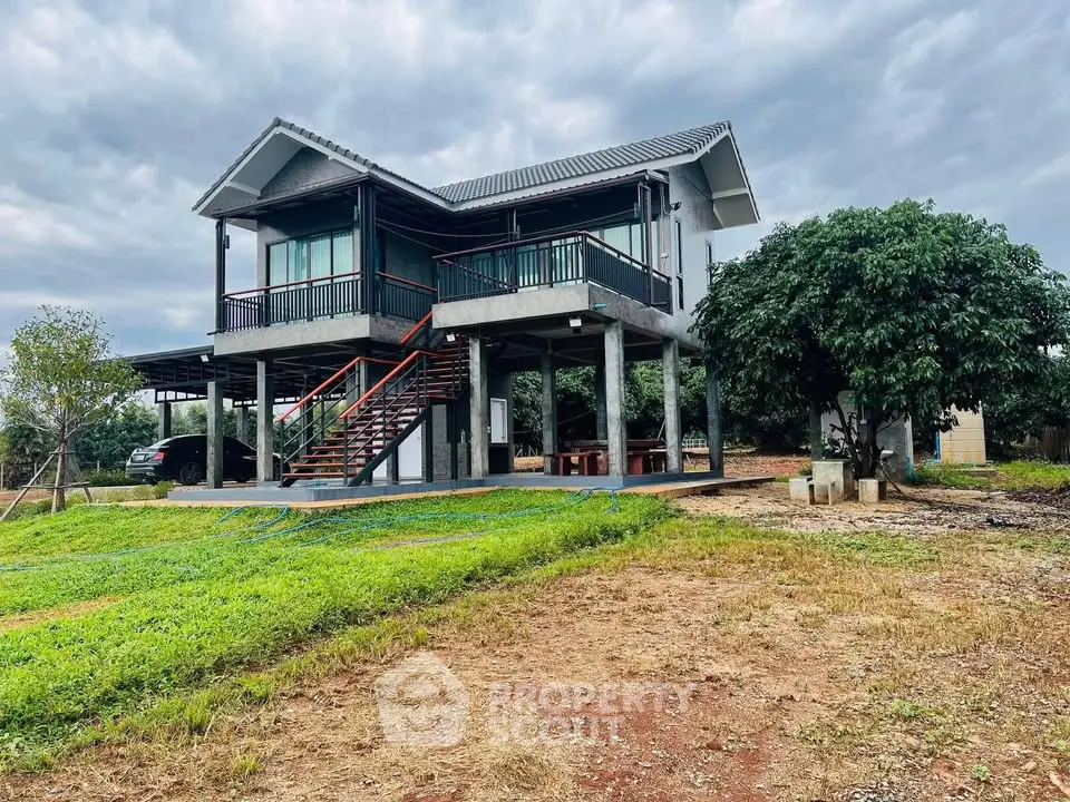 Charming elevated house with lush greenery and spacious outdoor area, perfect for serene living.